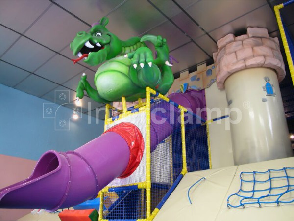 Interclamp tube clamp fittings forming the robust skeleton of a soft play jungle gym, with vibrant padding and play elements attached for children's enjoyment.